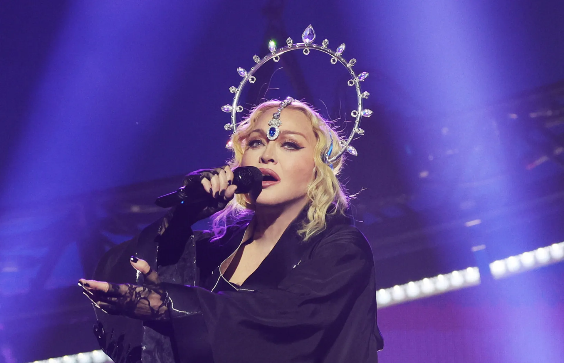 Madonna performando em uma cruz espelhada e com uma coroa de espinhos durante a Confessions Tour.