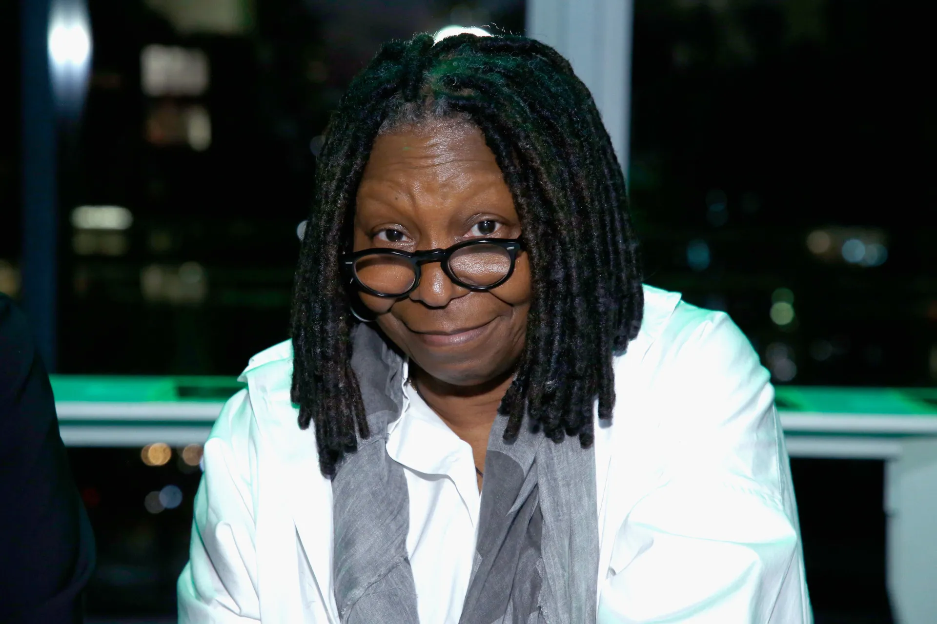 A atriz e apresentadora Whoopi Goldberg sorrindo calorosamente.