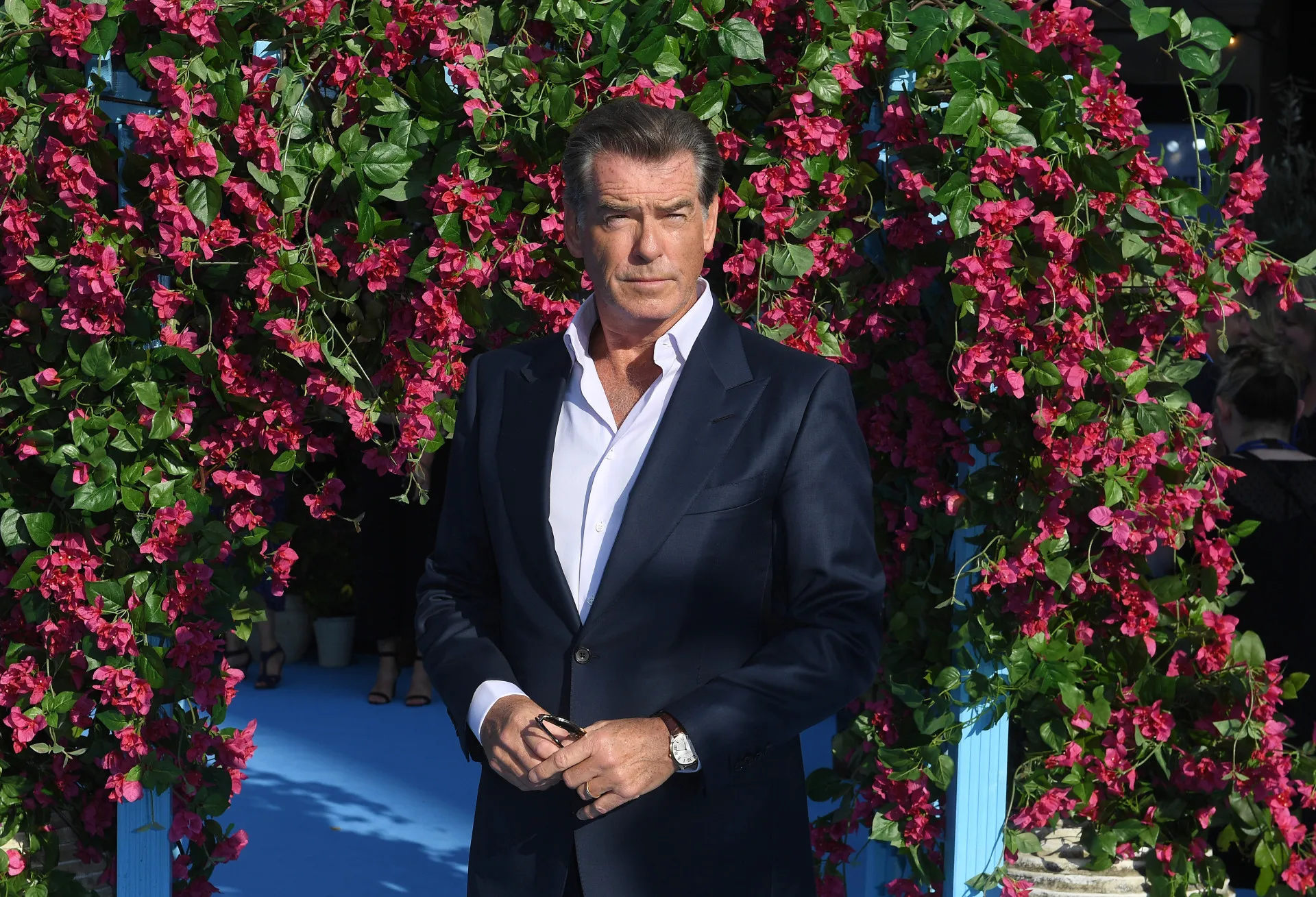 O ator Pierce Brosnan, famoso por interpretar James Bond, com um sorriso charmoso.