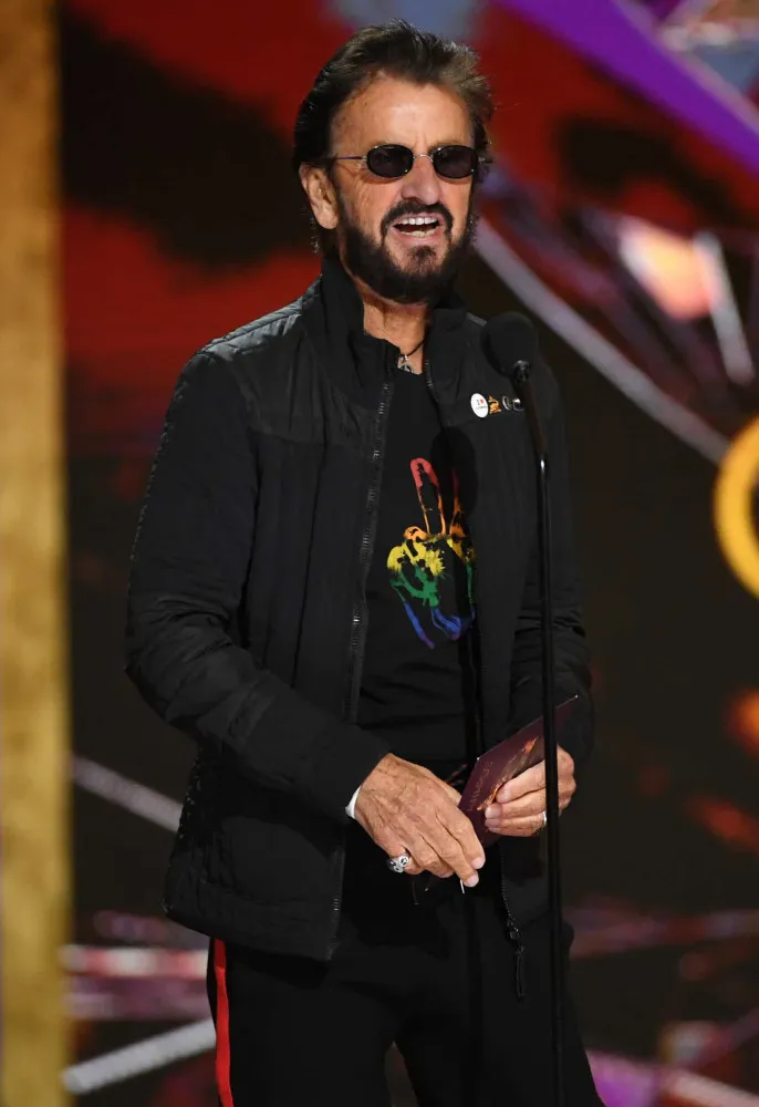 O ex-Beatle Ringo Starr fazendo seu famoso sinal de paz e amor.