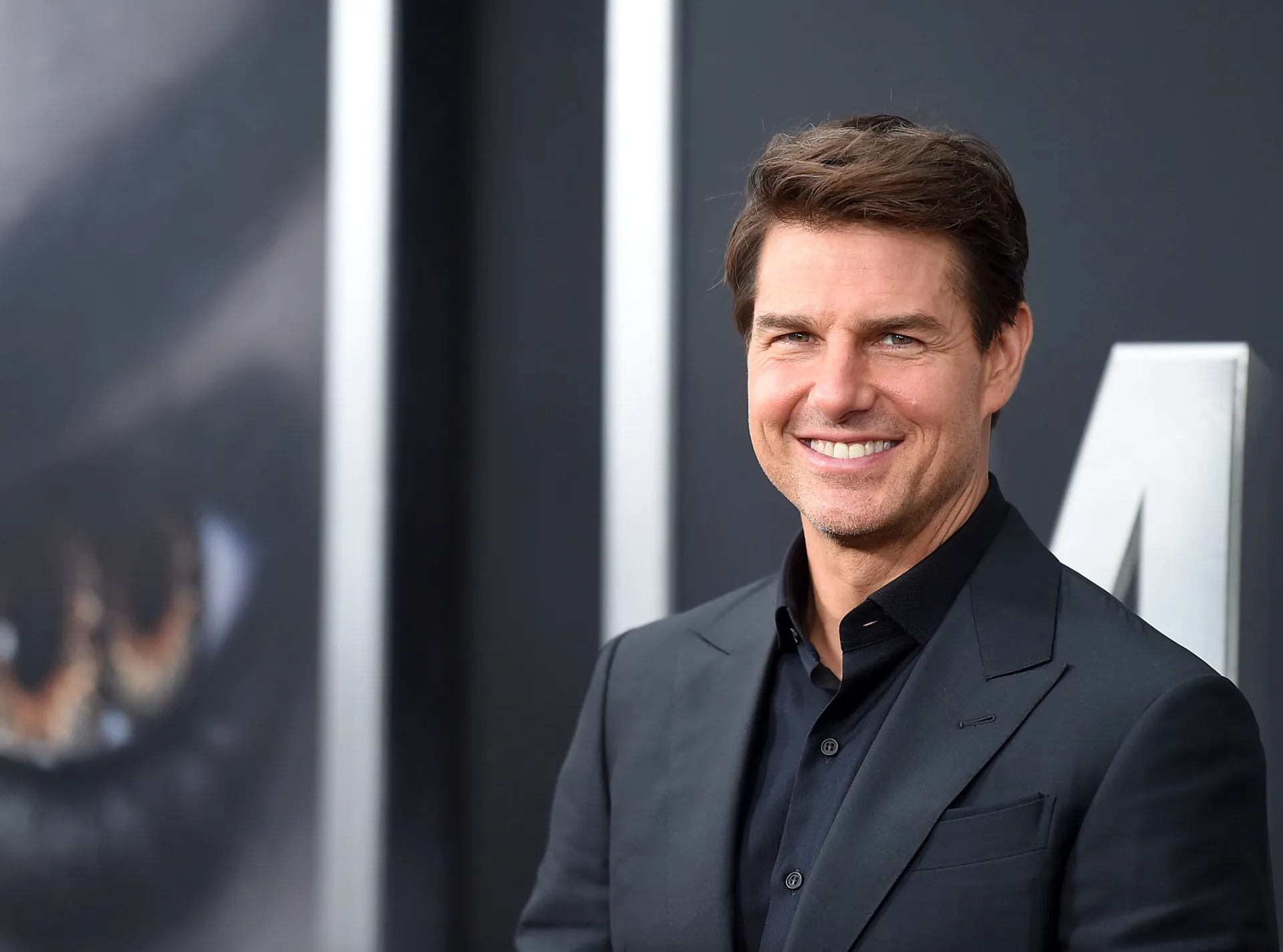 O astro de ação Tom Cruise com um sorriso característico.