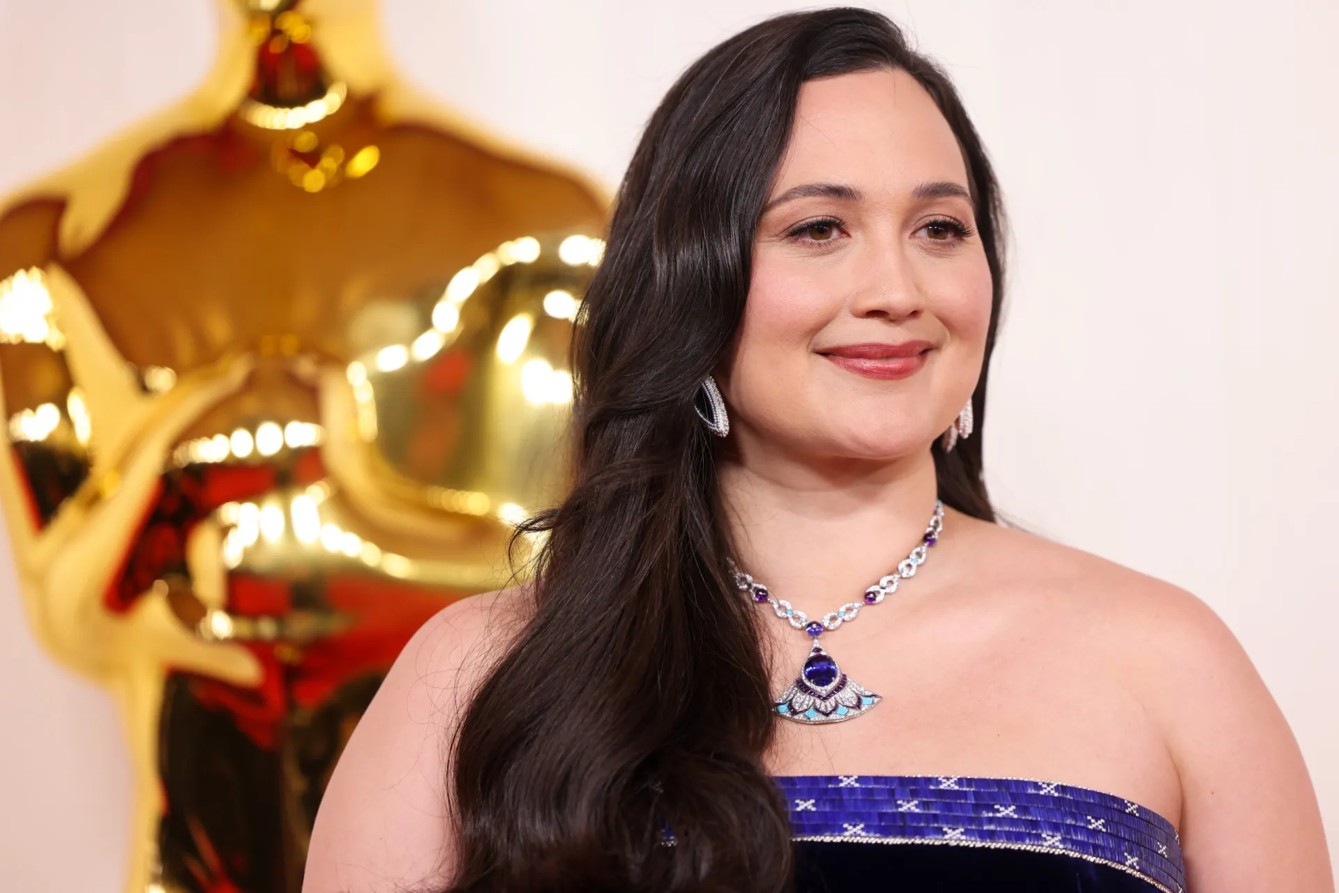 A atriz Lily Gladstone com um olhar poderoso em um tapete vermelho.