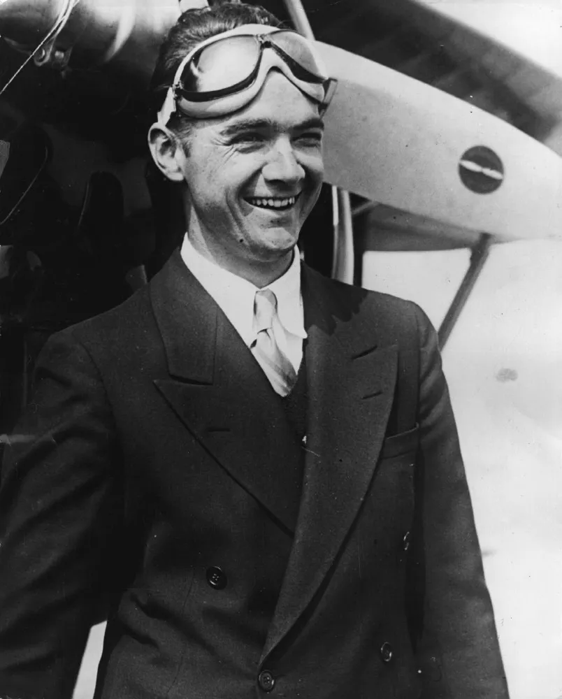 O magnata e aviador Howard Hughes em uma foto de época, parecendo poderoso e enigmático.