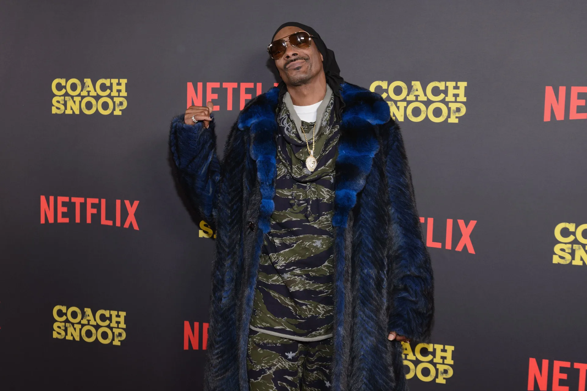 O rapper Snoop Dogg com seu estilo icônico, usando óculos escuros.