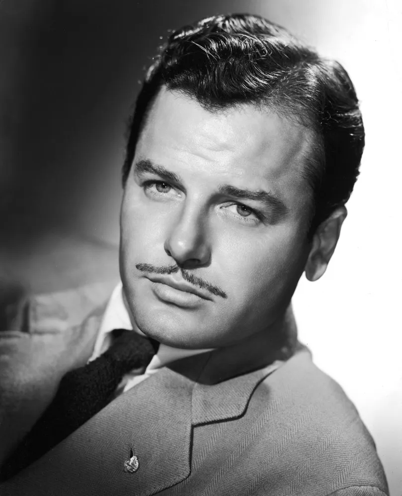 O ator Gig Young, vencedor de um Oscar, com um sorriso charmoso em uma foto de época.