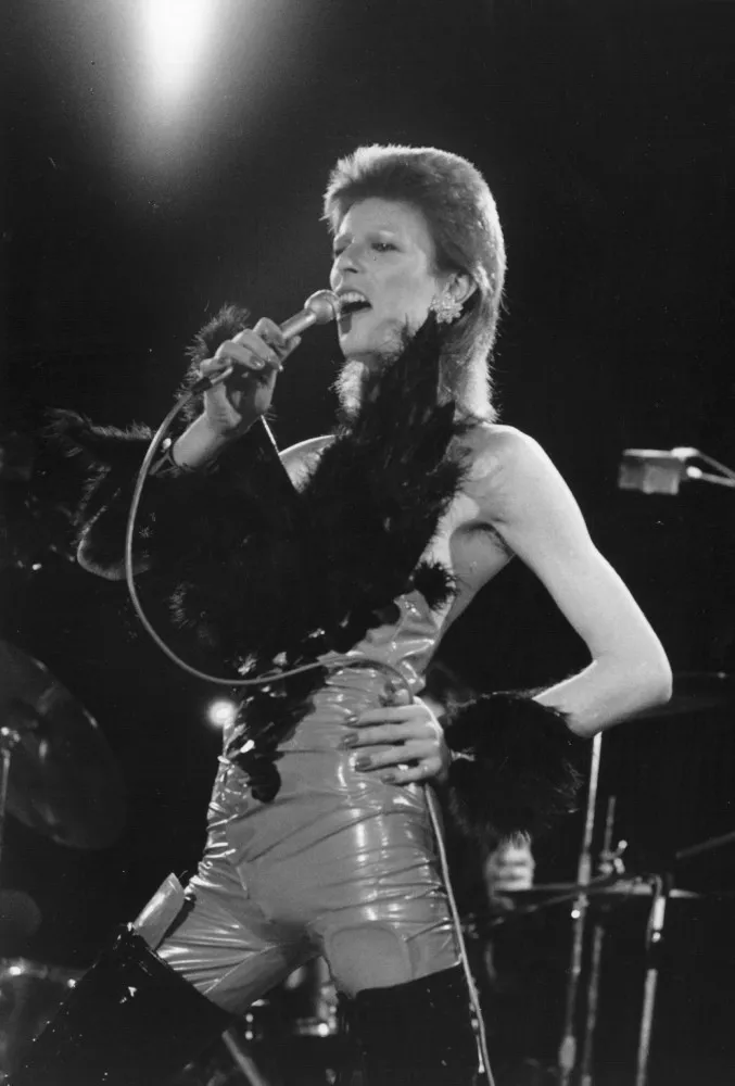 David Bowie com seu icônico cabelo vermelho e maquiagem marcante, representando a era Ziggy Stardust.