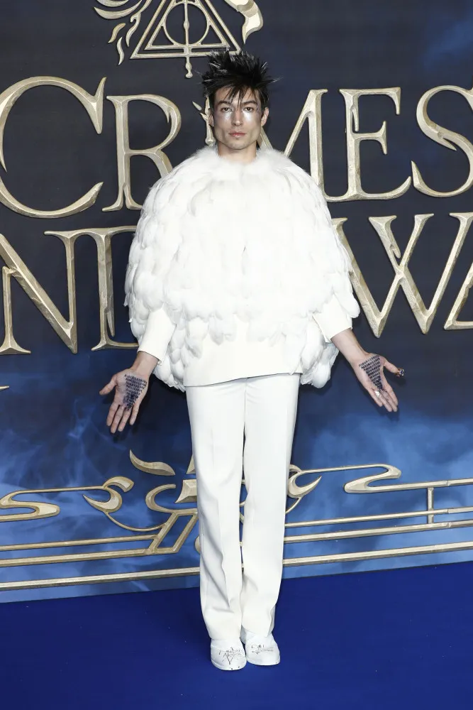 Ezra Miller em uma estreia de filme com um look dramático e extravagante, parecendo um casulo de plumas.