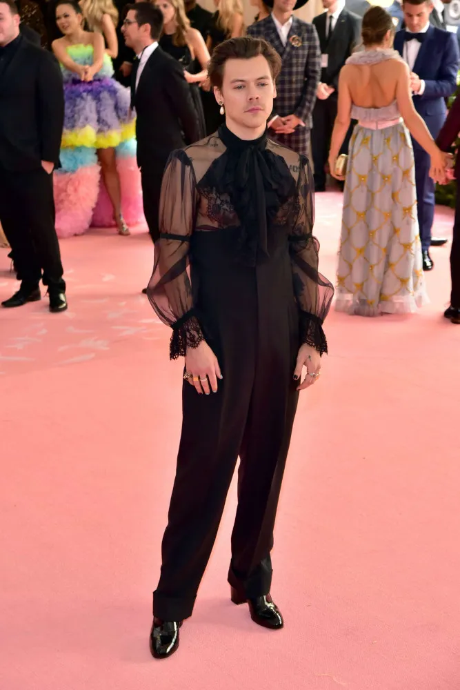 Harry Styles no Met Gala de 2019, com um macacão preto rendado e transparente.