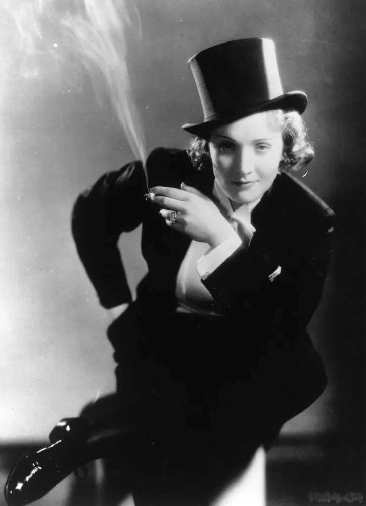 Marlene Dietrich vestindo um smoking completo, com cartola e gravata borboleta, em 1932.