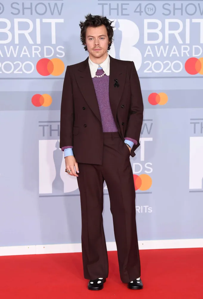 Harry Styles no palco com um look divertido e colorido, lembrando os grandes ídolos do rock.