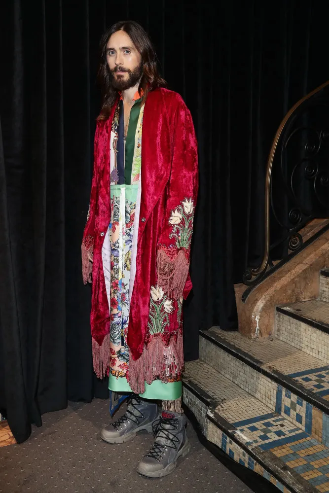 Jared Leto em um tapete vermelho com um look ousado e andrógino, desafiando convenções.