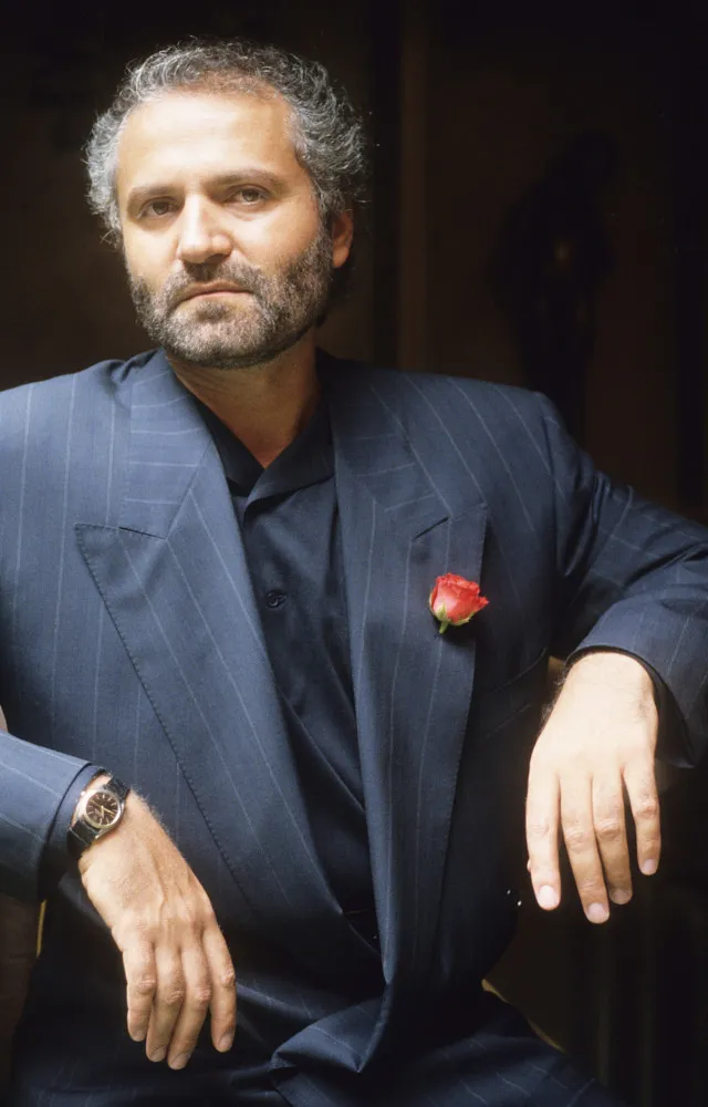 O estilista italiano Gianni Versace em um retrato elegante.