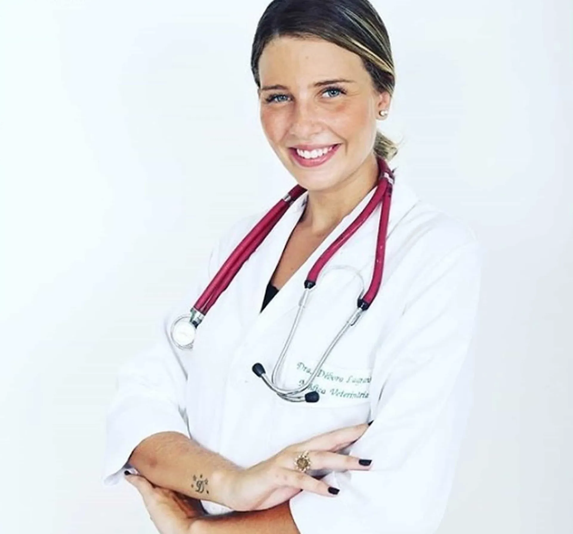 Debby Lagranha hoje, como médica veterinária, ao lado de um cachorro.