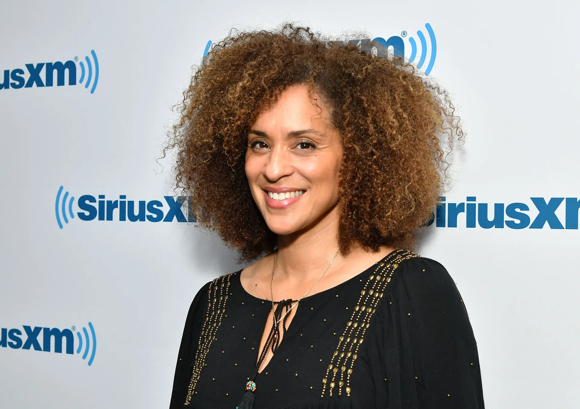 A atriz Karyn Parsons, a icônica Hilary Banks, sorrindo em um evento.
