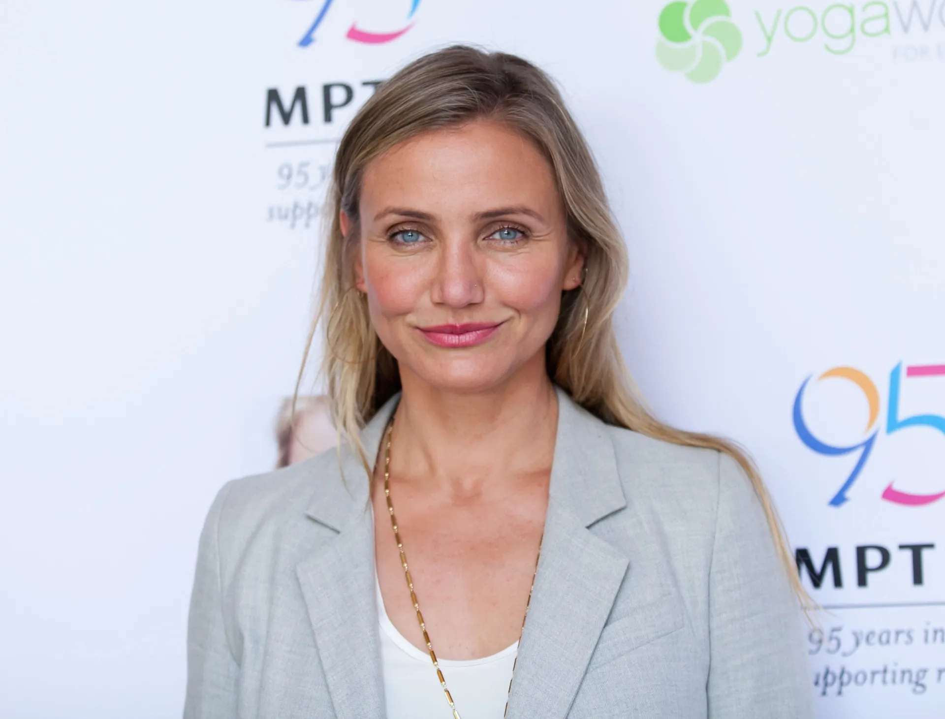 A atriz Cameron Diaz sorrindo em um evento de tapete vermelho.