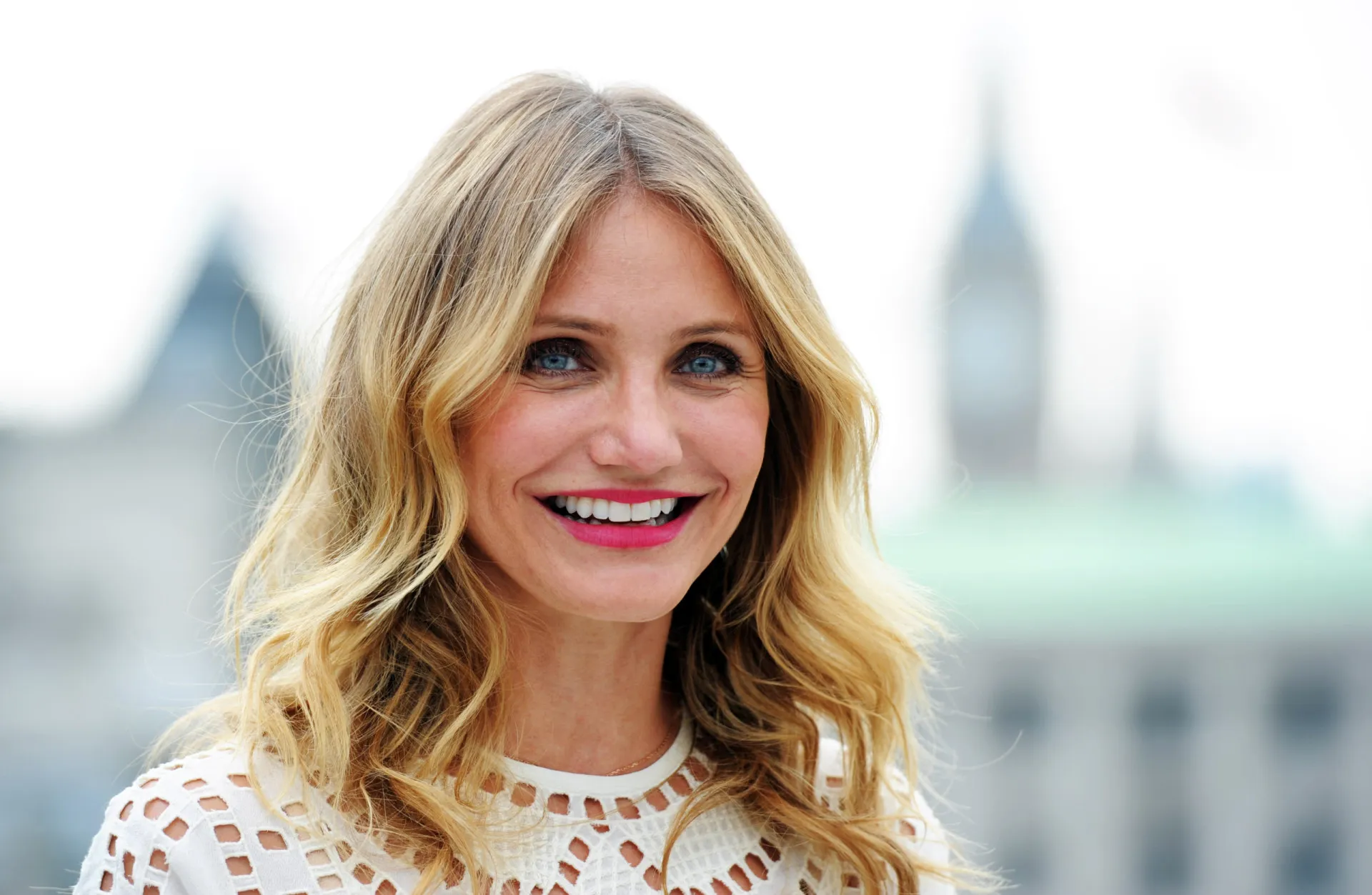 A atriz Cameron Diaz sorrindo em um evento de tapete vermelho.
