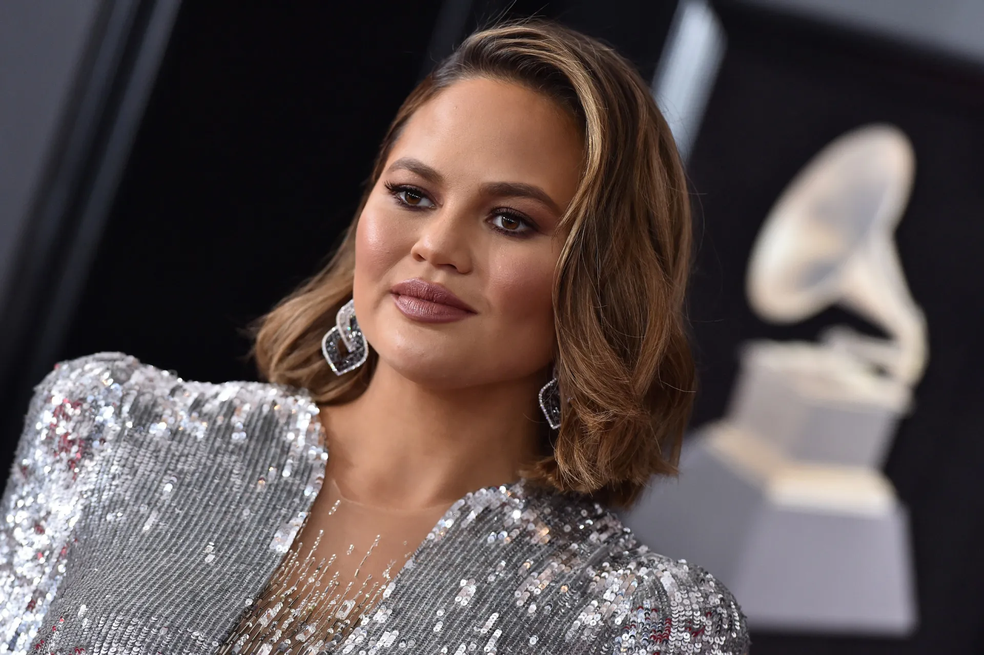A modelo e apresentadora Chrissy Teigen sorrindo em um evento de gala.