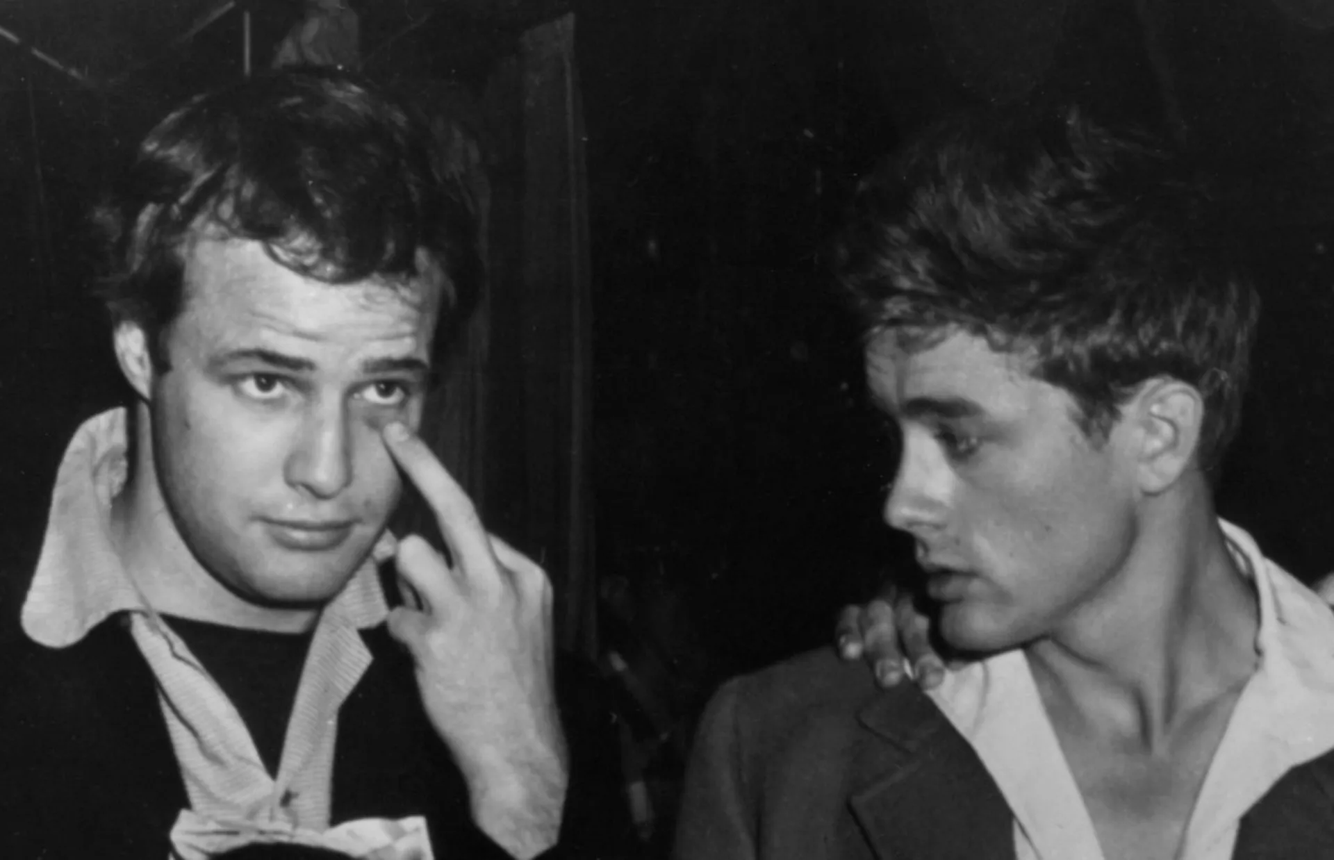 Uma montagem com os retratos dos atores Marlon Brando e James Dean em preto e branco.