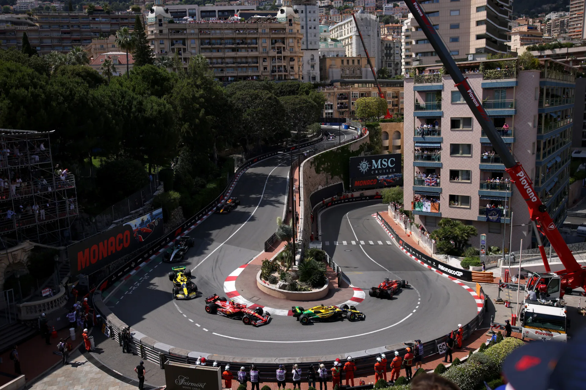 Carro de F1 navegando pelas ruas estreitas e curvas apertadas do circuito de Mônaco.