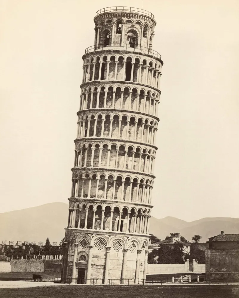 A famosa Torre Inclinada de Pisa, com turistas ao fundo tirando fotos criativas com o monumento.