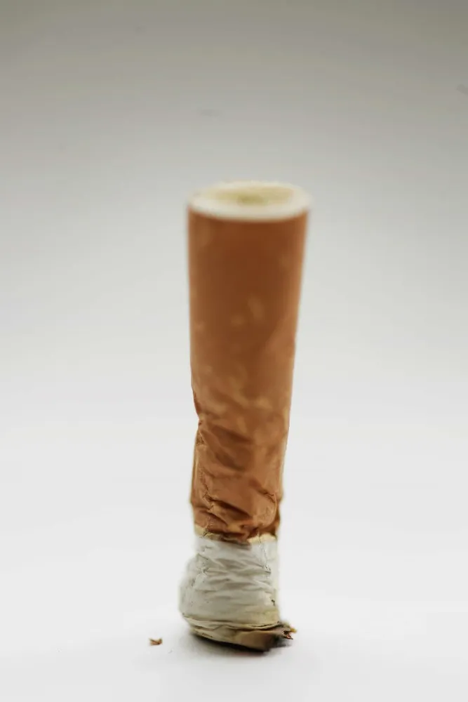 Mulher nos anos 1900 fumando um cigarro discretamente, em um ato que era considerado ilegal.