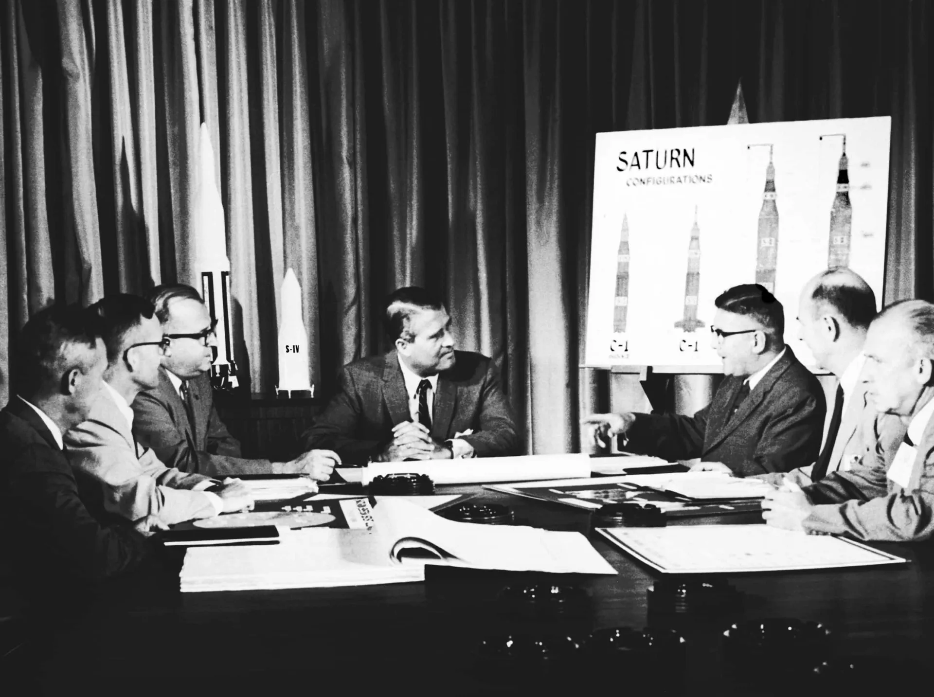 Wernher von Braun, cientista de foguetes, examinando um modelo com oficiais americanos.