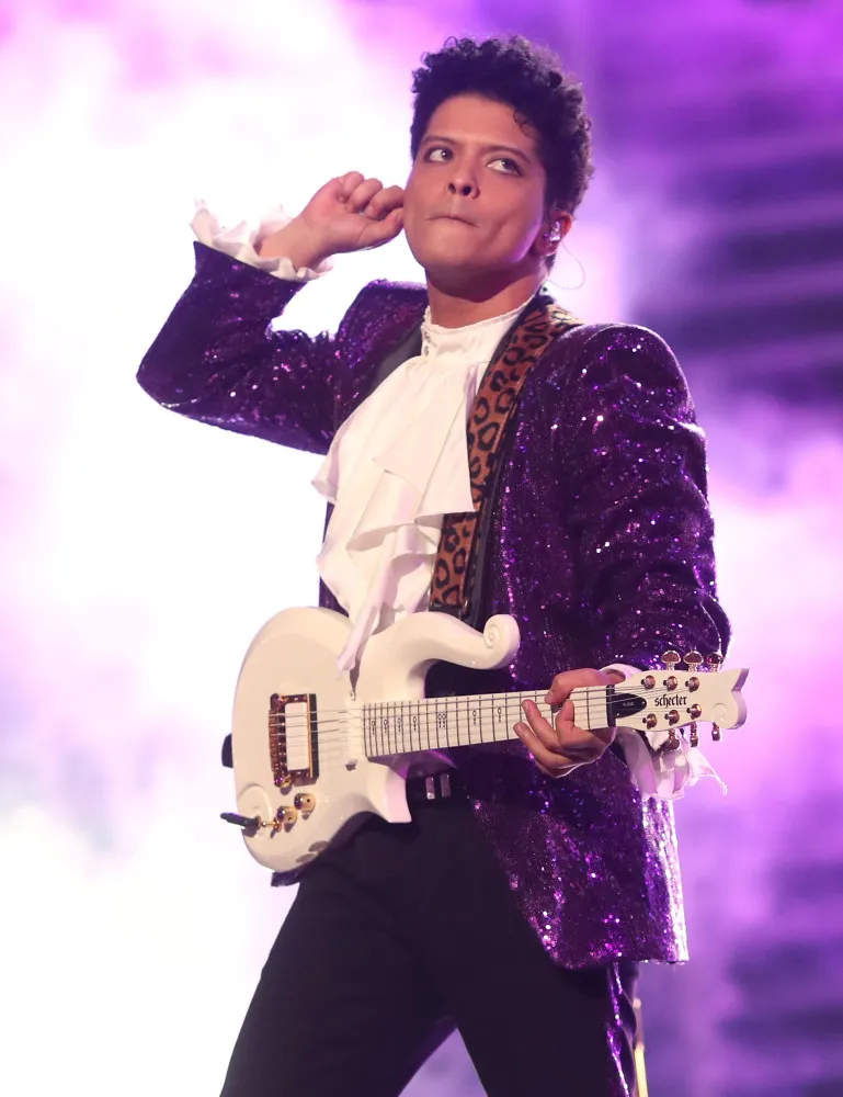 O cantor Bruno Mars se apresentando com energia no palco.