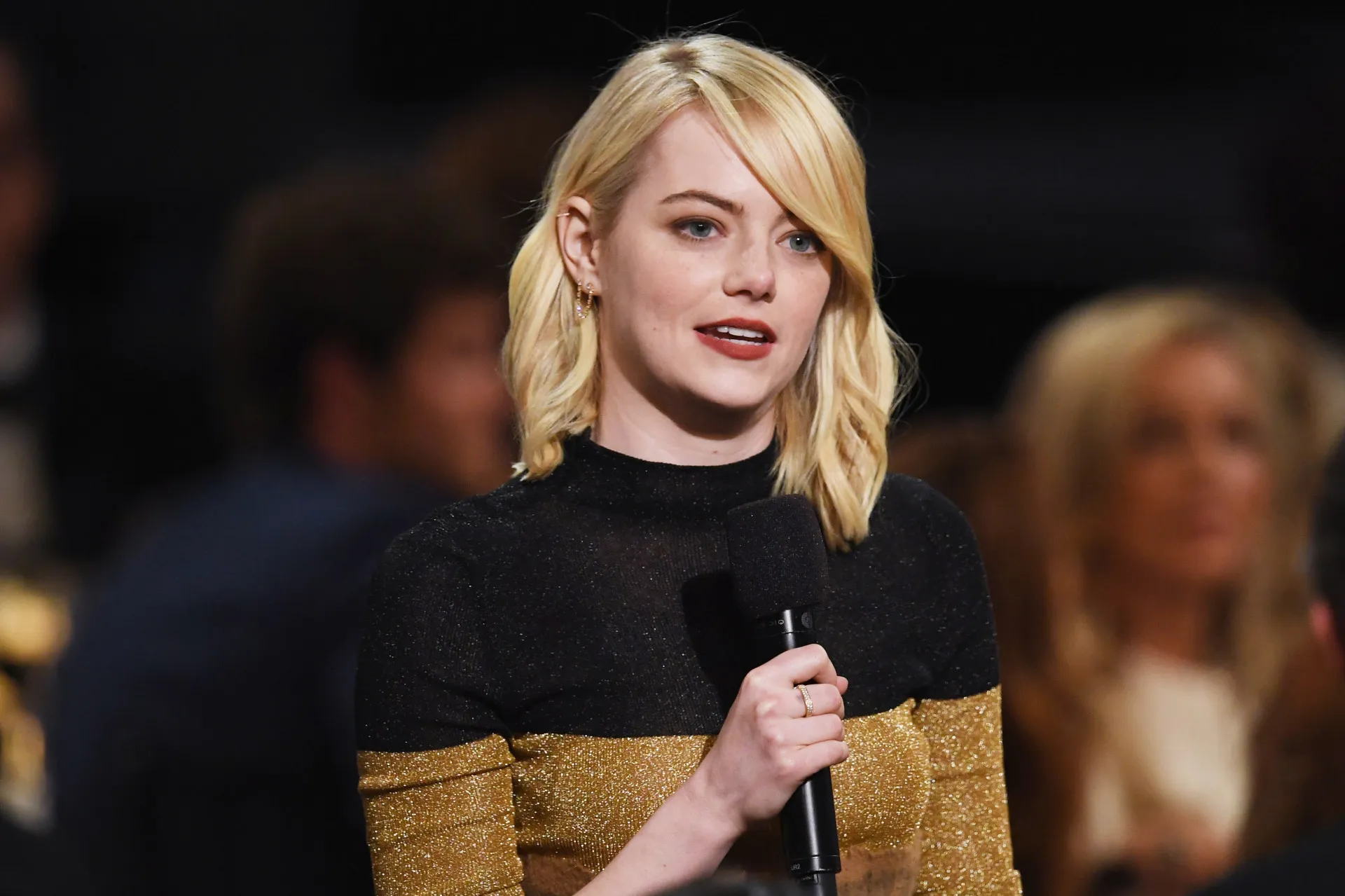 A atriz Emma Stone sorrindo de forma charmosa para a câmera.