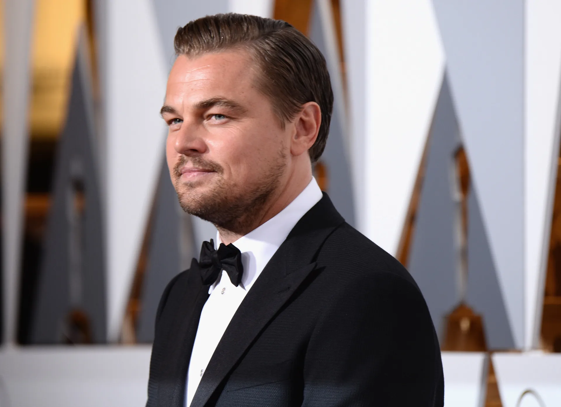 O ator Leonardo DiCaprio com um olhar penetrante e terno escuro.