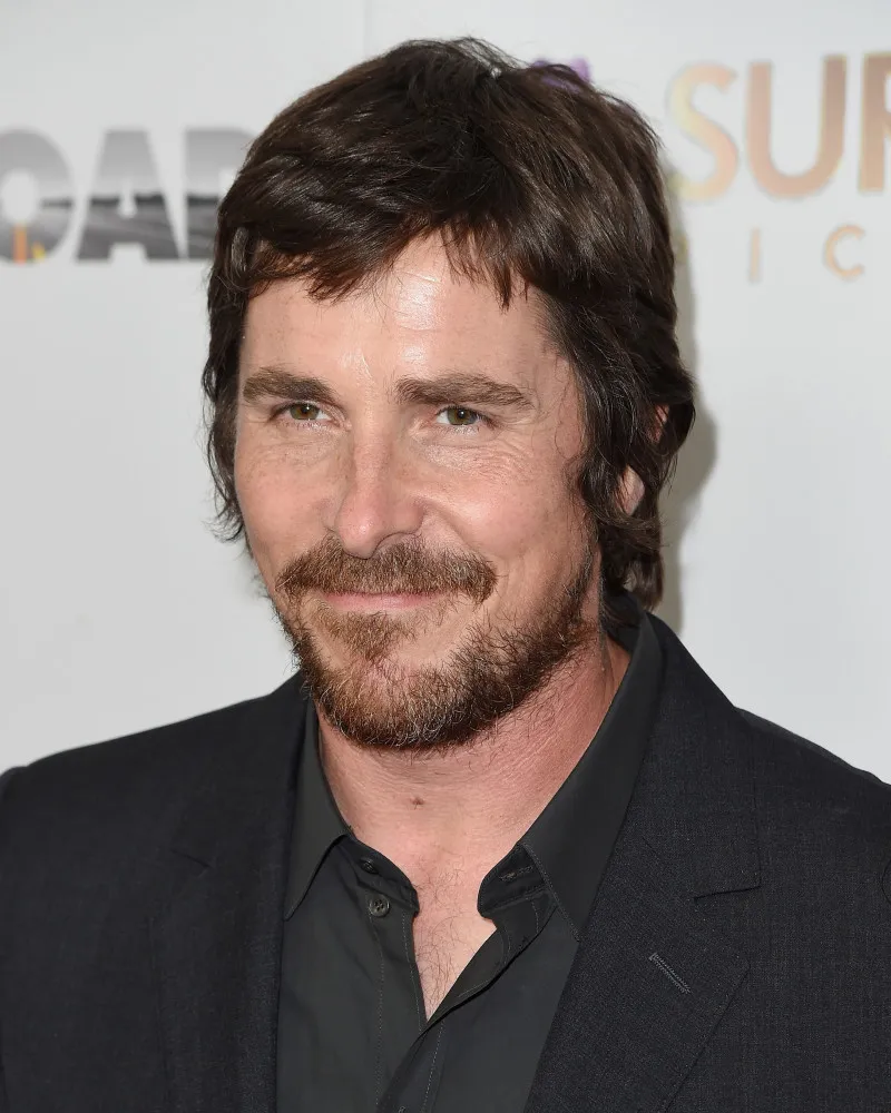 O ator Christian Bale com um olhar intenso e compenetrado.