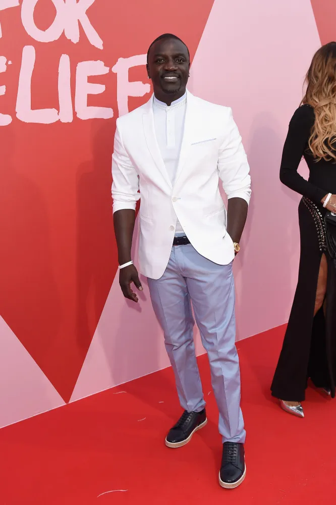 O cantor Akon usando óculos escuros e correntes de ouro.