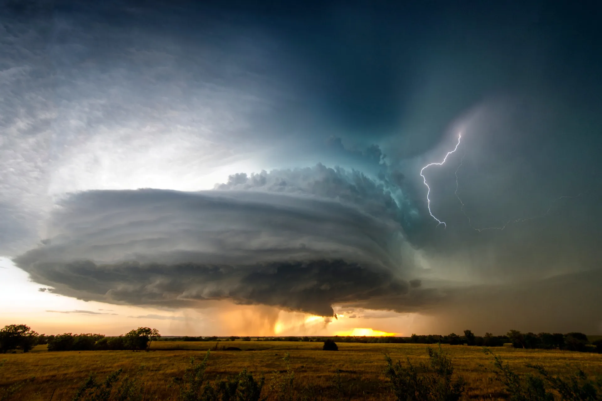 Uma enorme e ameaçadora nuvem de tempestade supercélula com uma estrutura em rotação claramente visível, parecendo uma nave-mãe.