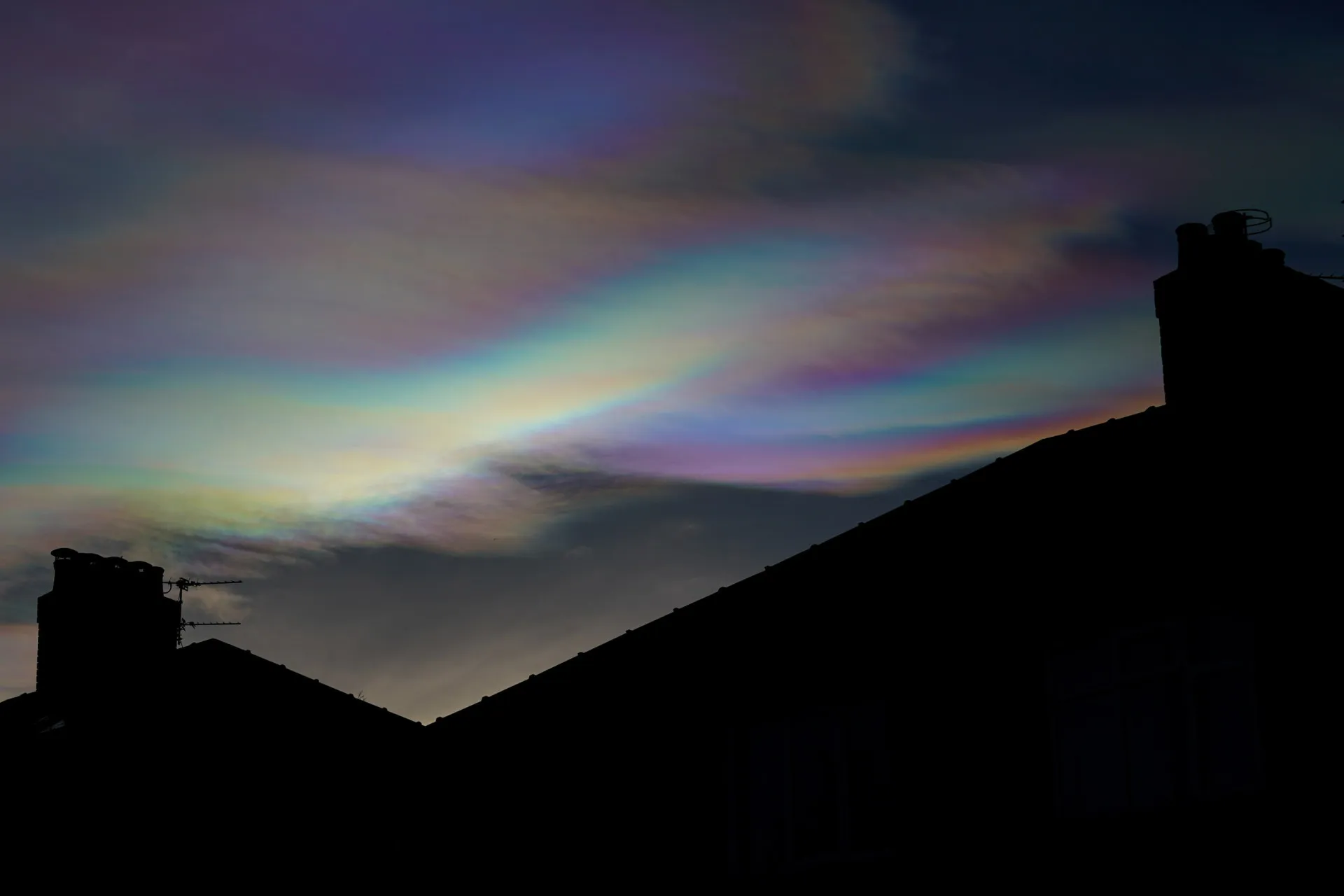 Nuvens finas e iridescentes com cores de arco-íris brilhando intensamente no céu polar.