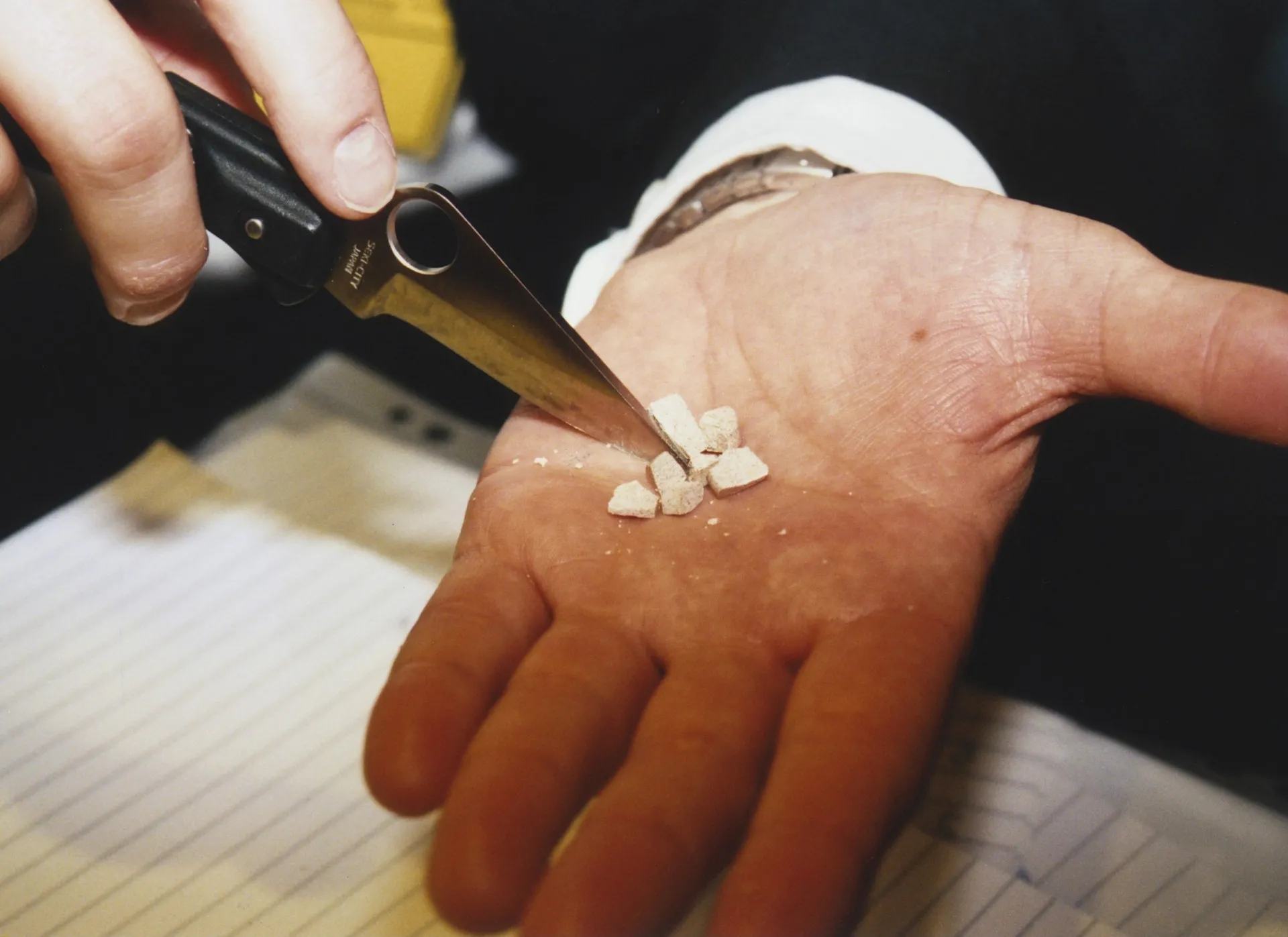 Um agente da DEA com equipamento de proteção segura uma amostra de fentanil apreendido.