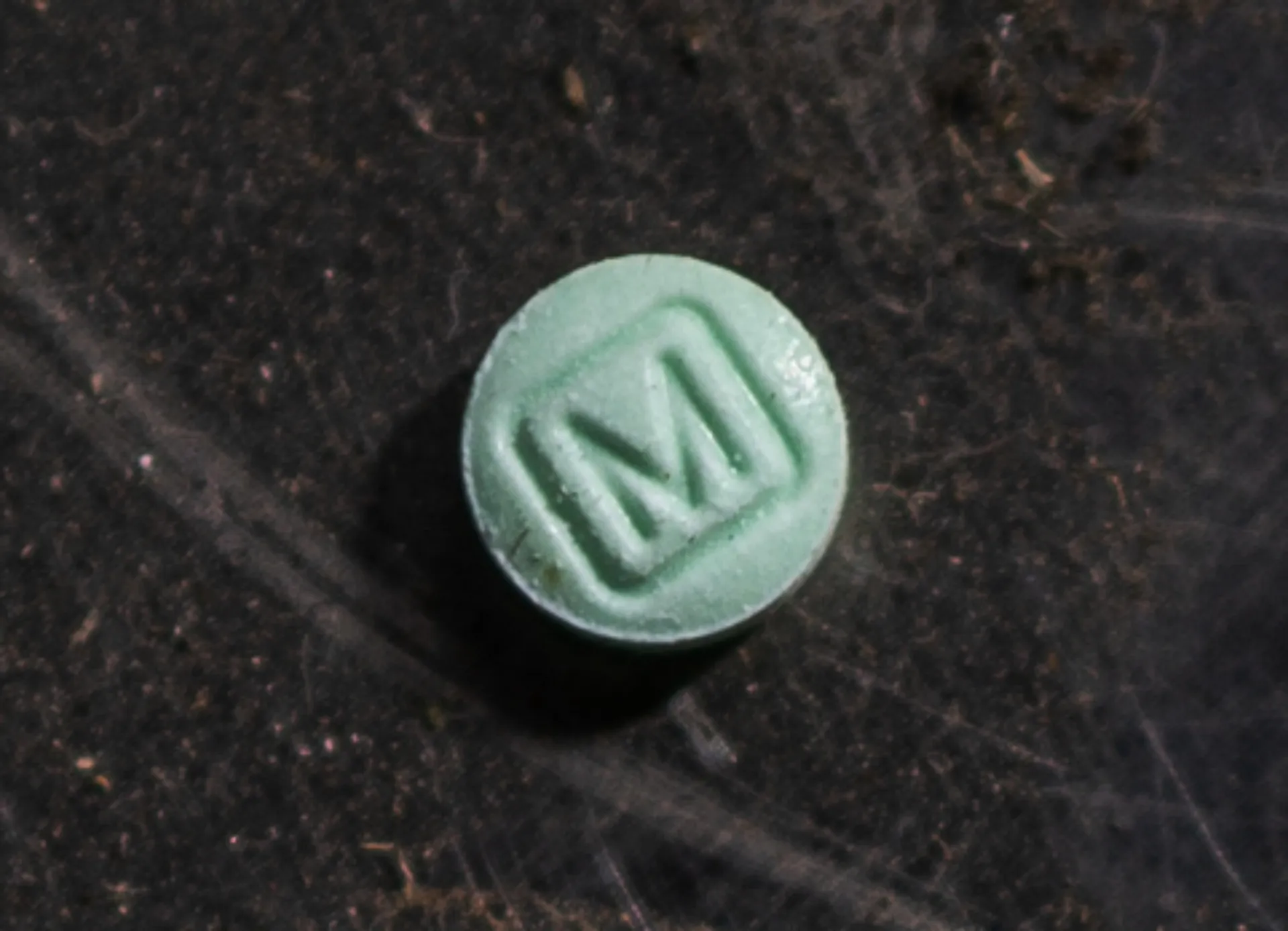 Um agente da DEA mostrando um cartaz da campanha 'One Pill Can Kill'.