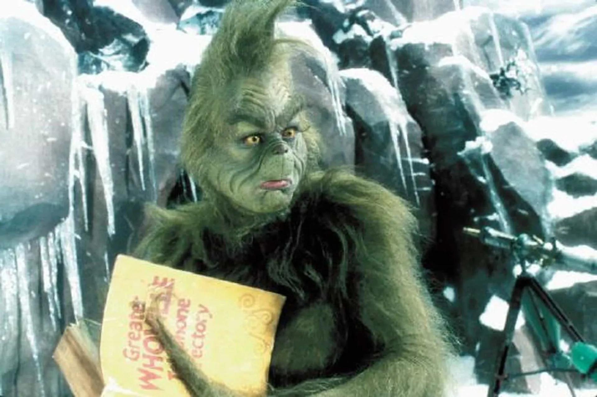 Jim Carrey irreconhecível sob a pesada maquiagem e o traje peludo do Grinch.
