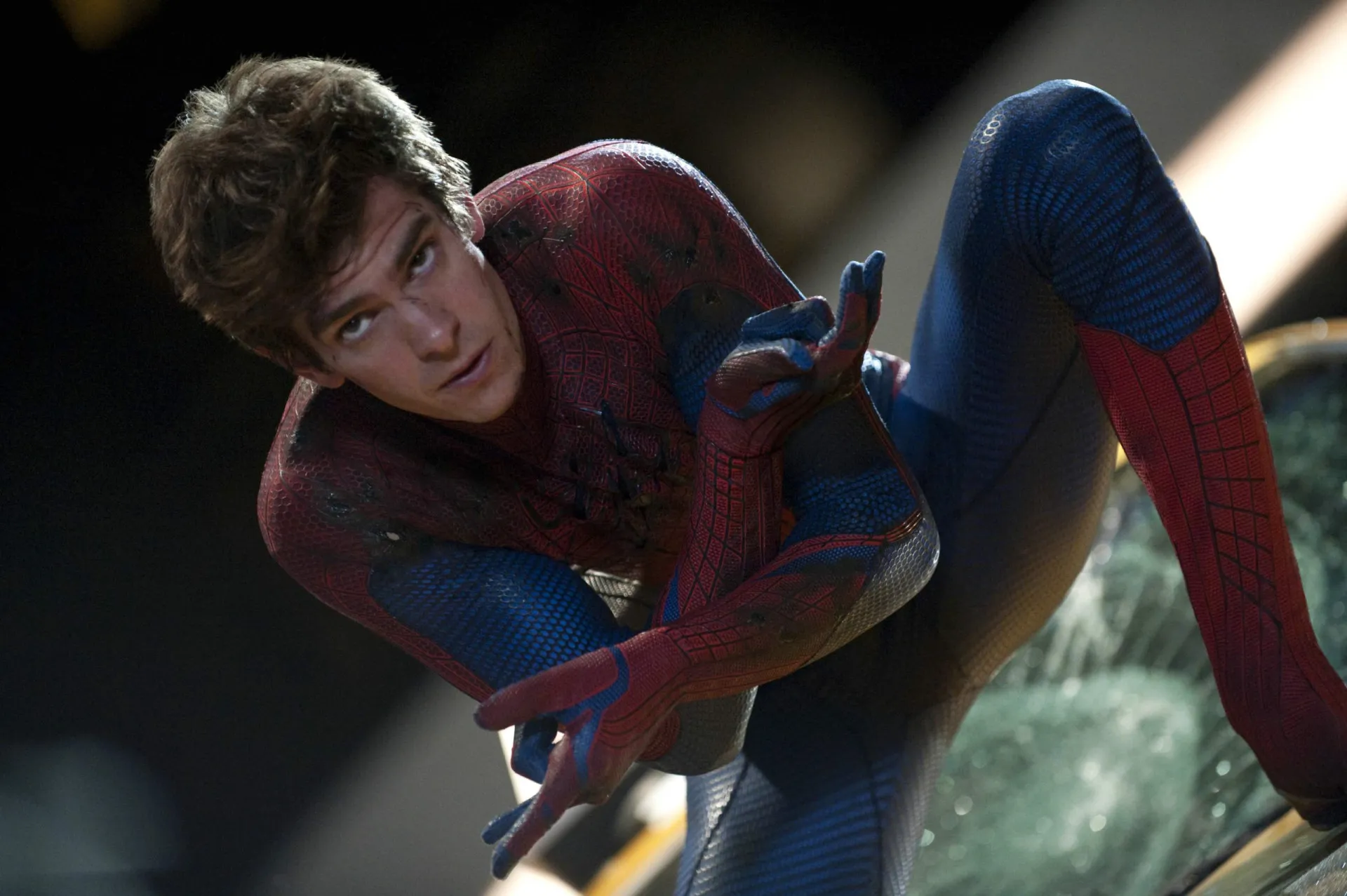 Andrew Garfield usando o traje completo do Homem-Aranha, em uma pose de ação.