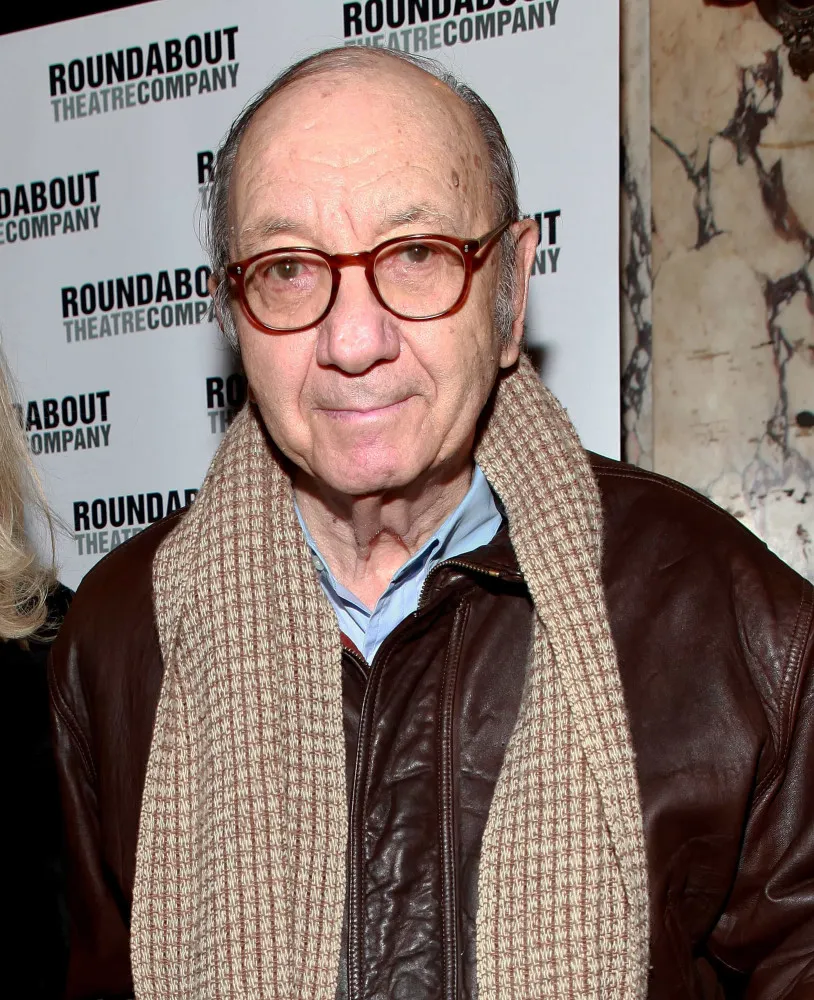 O roteirista Neil Simon, de óculos, segurando um roteiro e olhando pensativo.
