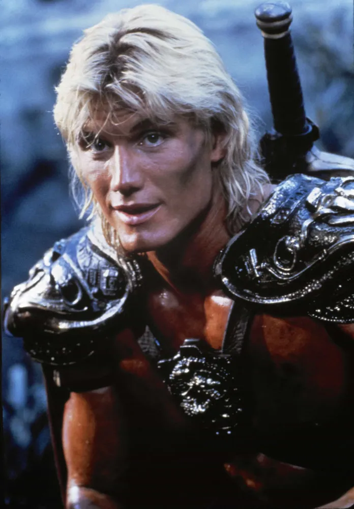 Dolph Lundgren como He-Man no filme 'Mestres do Universo', segurando sua espada.
