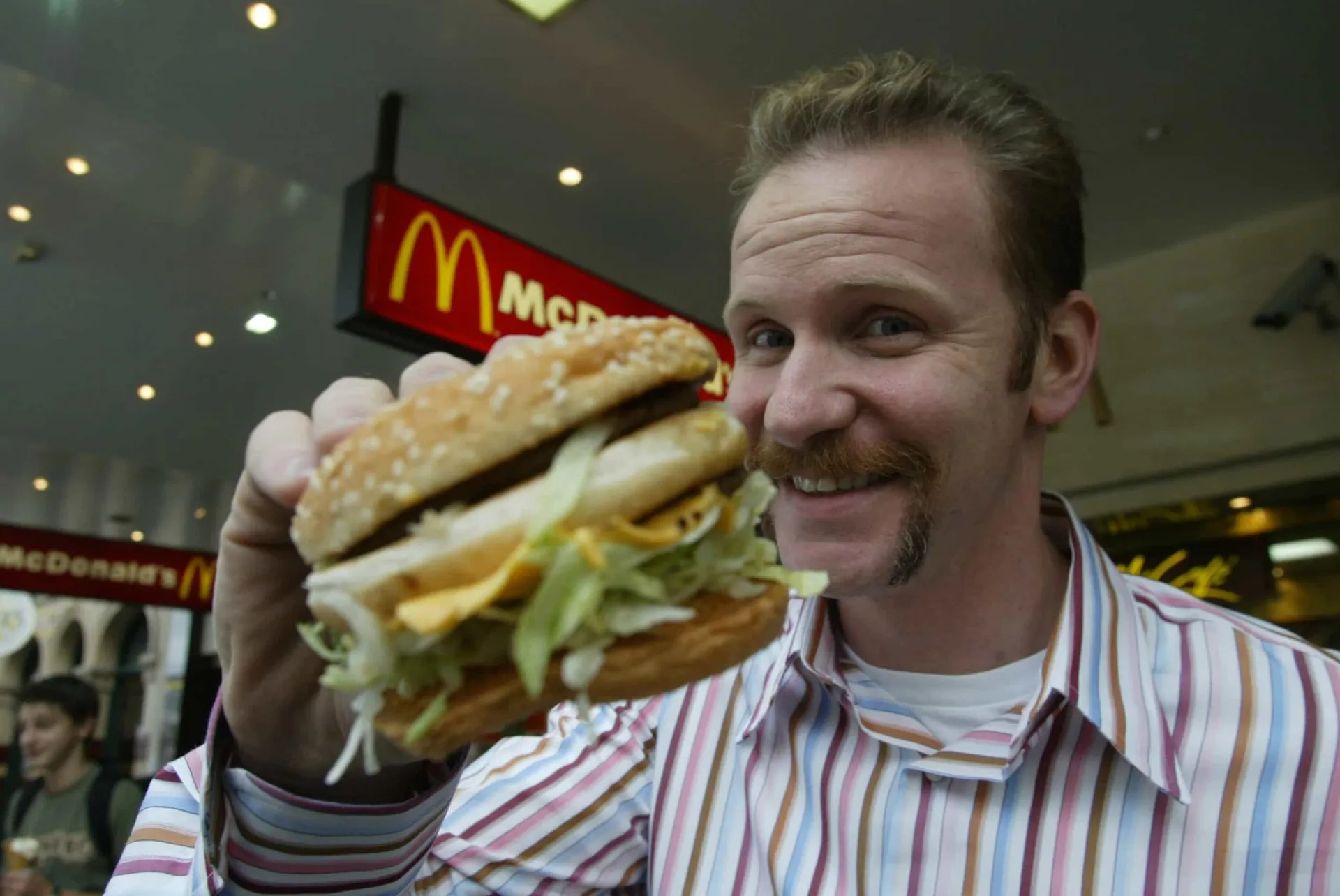 O cineasta Morgan Spurlock comendo um hambúrguer do McDonald's para seu documentário 'Super Size Me'.