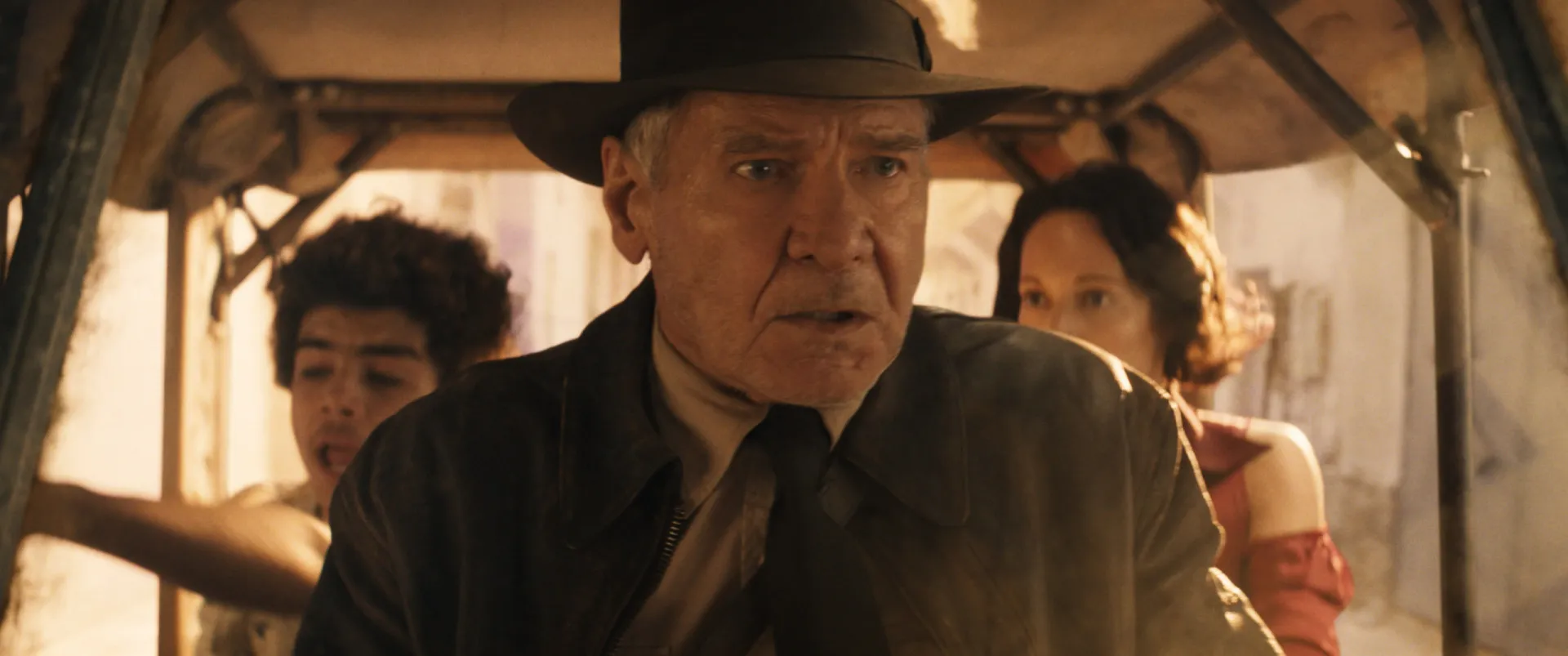Harrison Ford como um Indiana Jones mais velho em 'A Relíquia do Destino', com um olhar cansado.