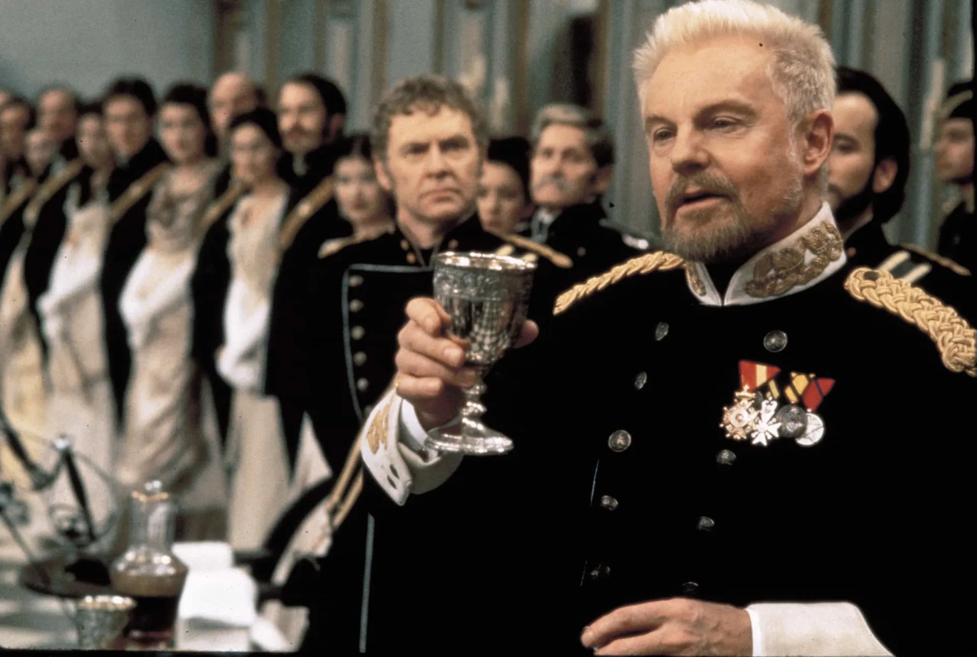 Kenneth Branagh como Hamlet, segurando uma espada em uma cena do filme.