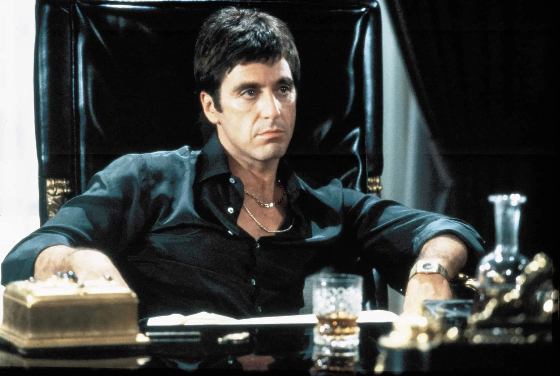 Al Pacino como Tony Montana no filme 'Scarface', em uma pose icônica.