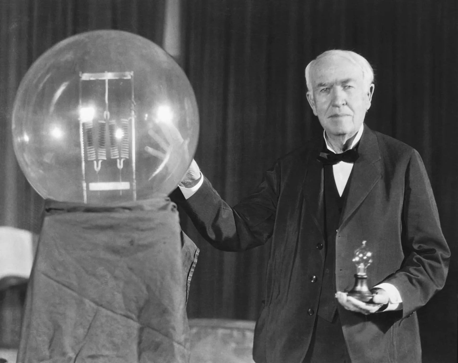 Jovem Thomas Edison em seu laboratório, cercado por equipamentos.