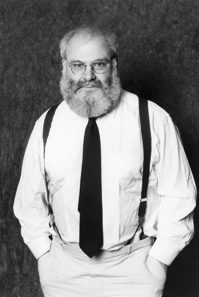 O neurologista Oliver Sacks sorrindo, um homem conhecido por sua empatia e curiosidade sobre a mente humana.
