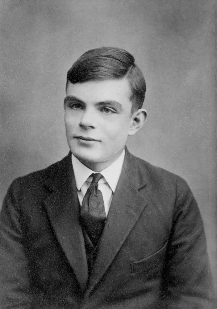 Retrato em preto e branco de Alan Turing, o matemático britânico que parece pensativo.