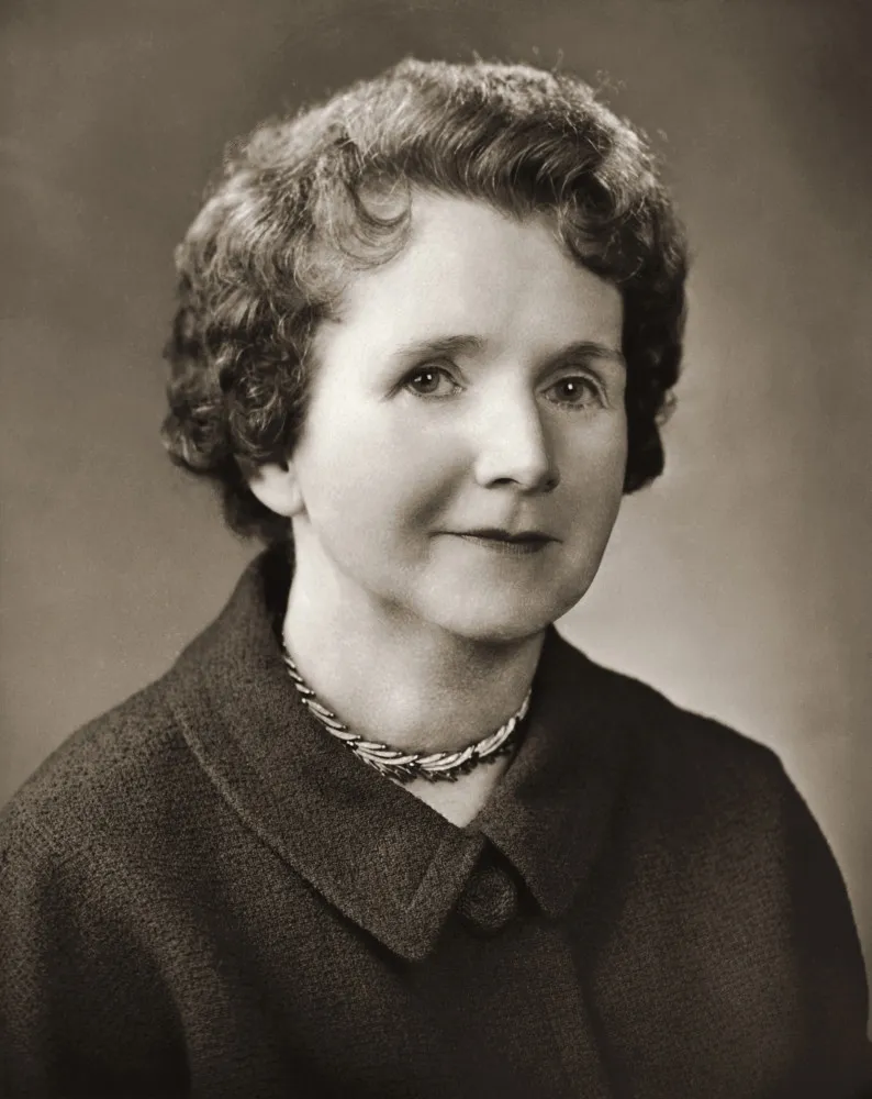 Rachel Carson, bióloga marinha, trabalhando em seu escritório, cercada de livros e pesquisas.