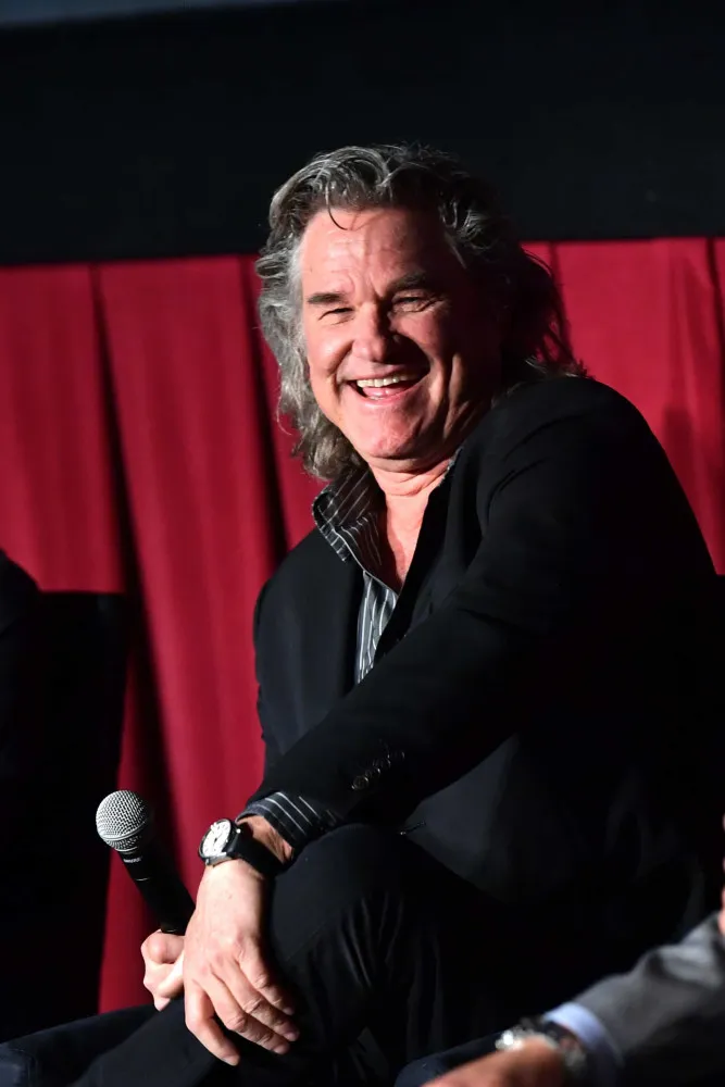 Kurt Russell mais velho, com barba e cabelo grisalhos, exibindo um visual distinto e maduro.