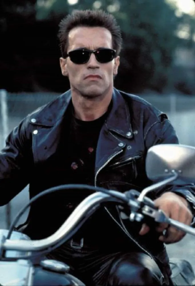Arnold Schwarzenegger jovem, com o corpo musculoso de fisiculturista, no auge de sua forma física.
