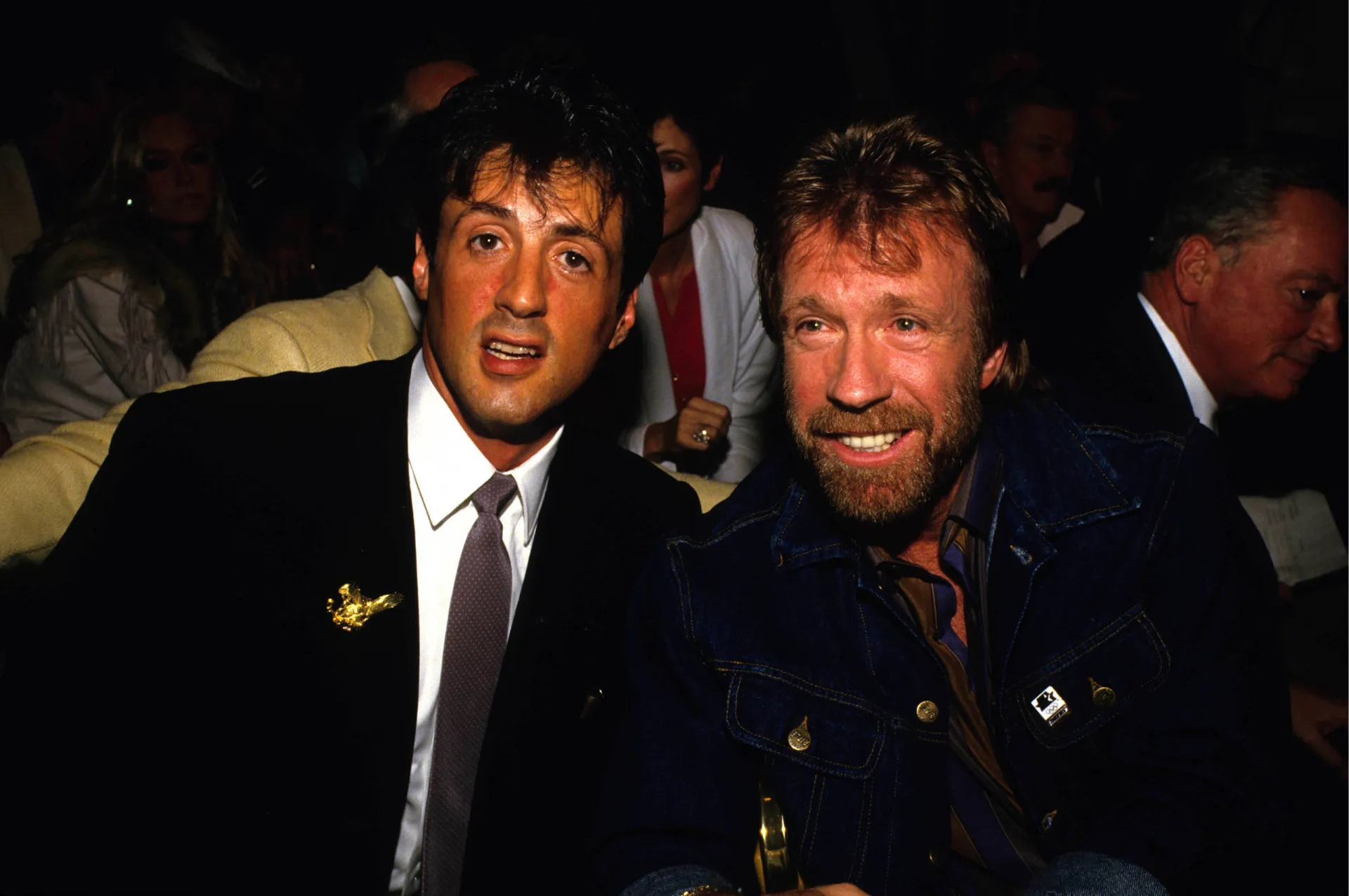 Chuck Norris mais velho, de barba branca e chapéu de cowboy, sorrindo.